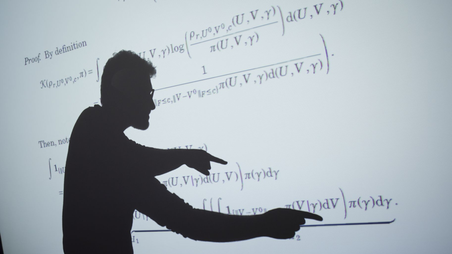 homme montrant un tableau avec des formules mathématiques